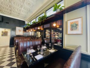 Walloon’s – Sconces, tin tile ceiling and plant shelves add layers of design details. (Photo by Courtney Dabney)