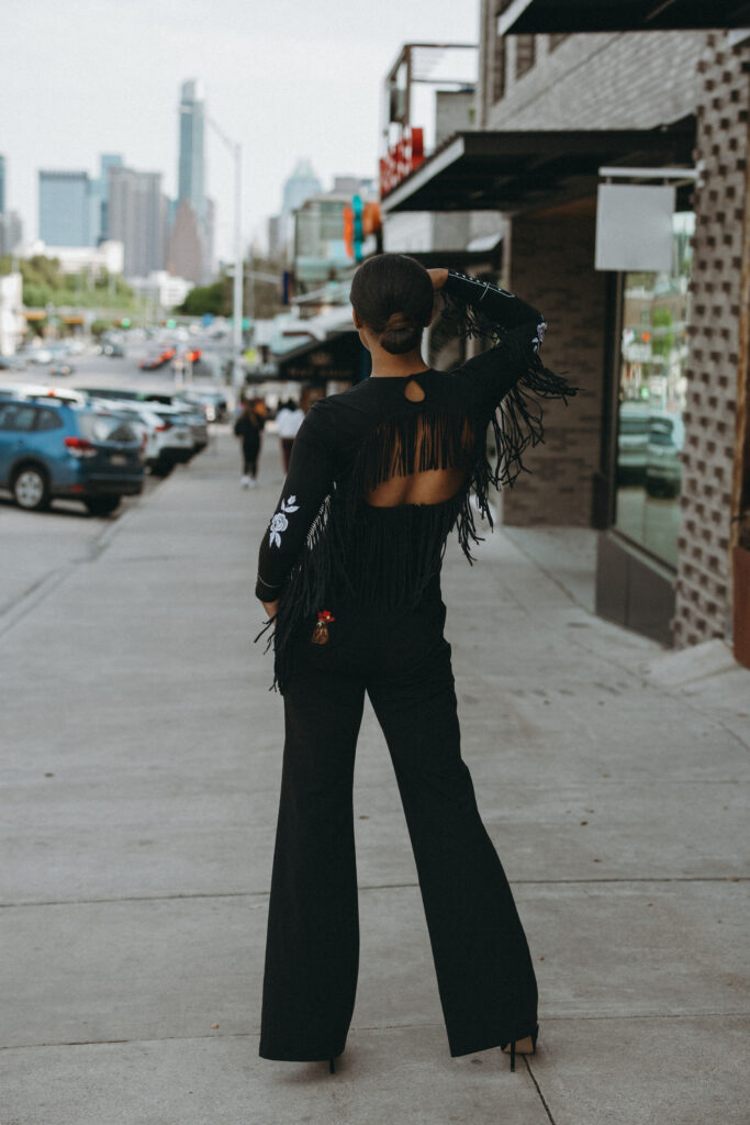 Fringy Baby was inspired by an open back gown with fringe lining the back and arms. The flower detailing is inspired by Lee's mothers’ original rodeo jacket. 