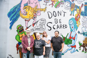 Redbud Arts Center president Gus Kopriva, executive director Tanya Peterson, Marjory Johnston, Carlos Alcaraz (Empyre) get together at the "Don't Be Scared" mural honoring the late artist Daniel Johnston. (Photo by Saranna Zhang/Kevin Zhang Photography)