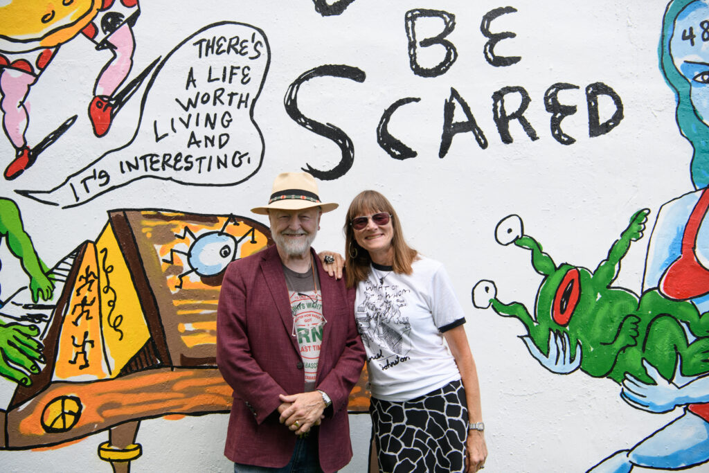 Redbud Arts Center President Gus Kopriva, Executive Director Tanya Peterson at the "Don't Be Scared" mural at Redbud Arts Center  (Photo by Saranna Zhang/Kevin Zhang Photography)