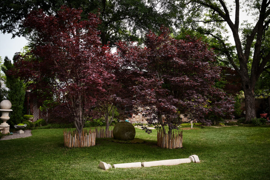 The trunks of Japanese maples are shielded from dog Riffi’s scratches by bamboo stalks. When a column and capital didn’t work for another project, Robert Bellamy buried part in the ground. A pecan tree in the background has been there since the 1920s. (Photo by Pär Bengtsson)