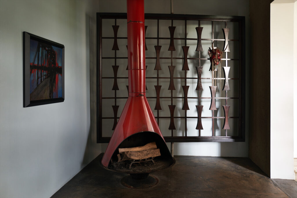  room added years ago to the original garden house are a 1950s fireplace and ‘60s-era wood screen from Sputnik Modern. Early 20th-century horsehair devil mask from Mexico. (Photo by Pär Bengtsson)