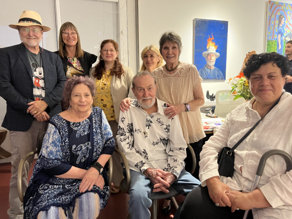 Wayne Gilbert (center) surrounded by family, friends, and fans at his last art show, Saturday, July 8, 2023. Seated, from left, artist Susan Plum, Bard professor Dr. Susan Aberth. Standing, from left: Redbud Arts Center's Gus Kopriva and Tanja Peterson, G Spot Contemporary Art Space director Doria Goldman, Court of Appeals Justice Meg Poissant, Beverley Gilbert. 