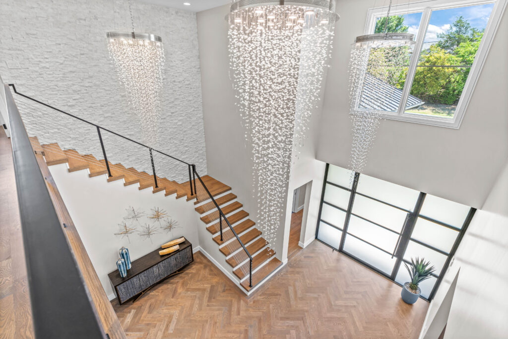 108 Legacy Court - entry hall with chevron flooring and dramatic waterfall lighting soaring two stories.