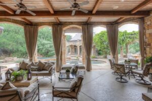 Six – 6901 Sanctuary Lane covered patio with views across the wet area to the separate pool house.