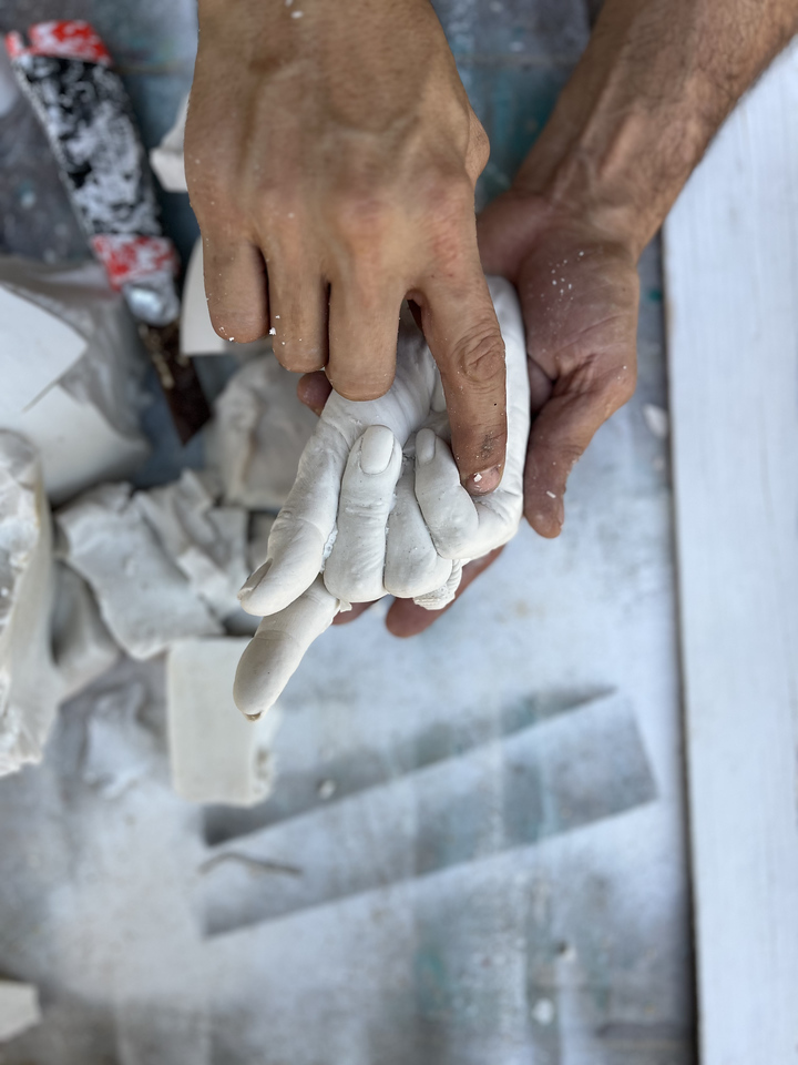 Patrick Medrano works with the cast of Shelby Hodge's hand, part of a piece for the Houston Arts Alliance gala auction. (Photo by Katy Anderson)