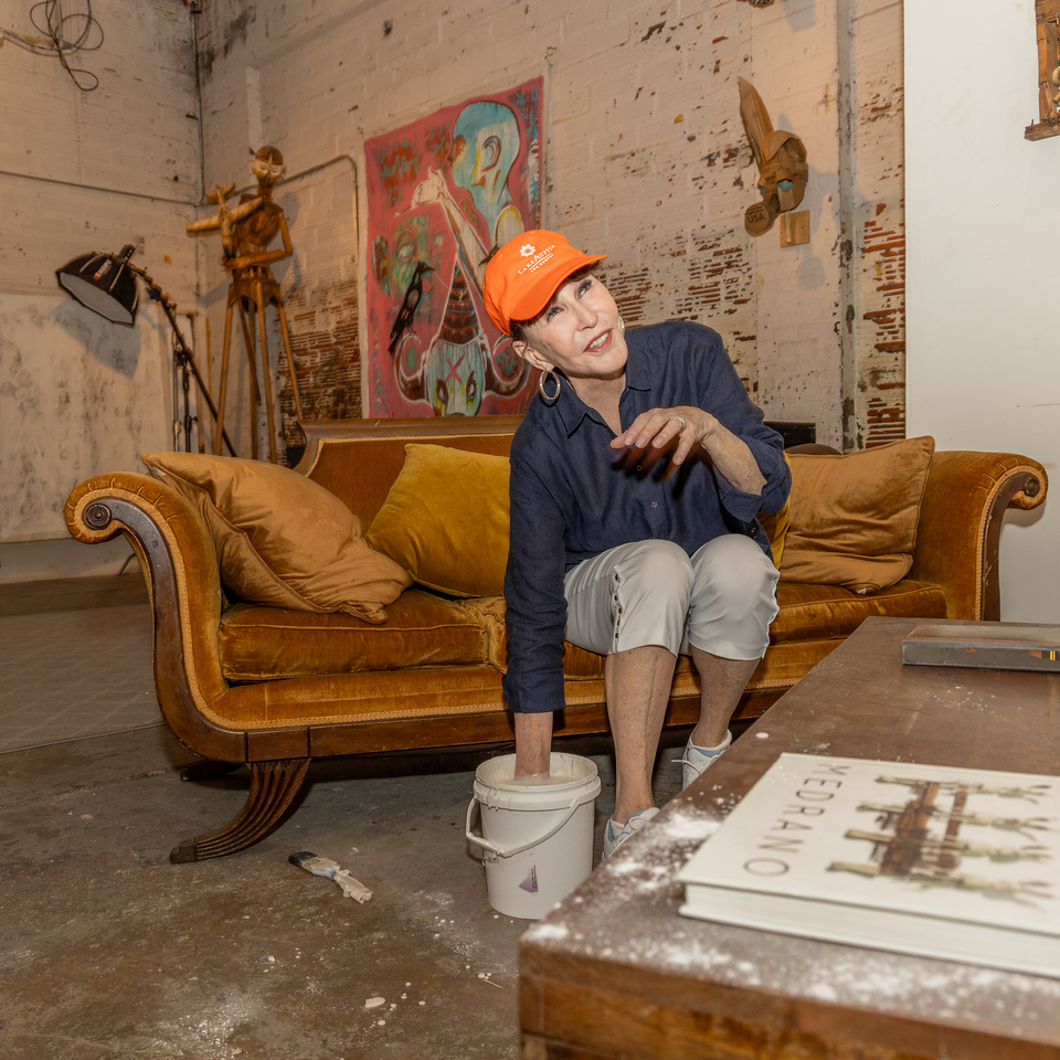 Shelby Hodge is a good sport dipping her hand into a bucket of silicone rubber in the name of art. (Photo by Katy Anderson)