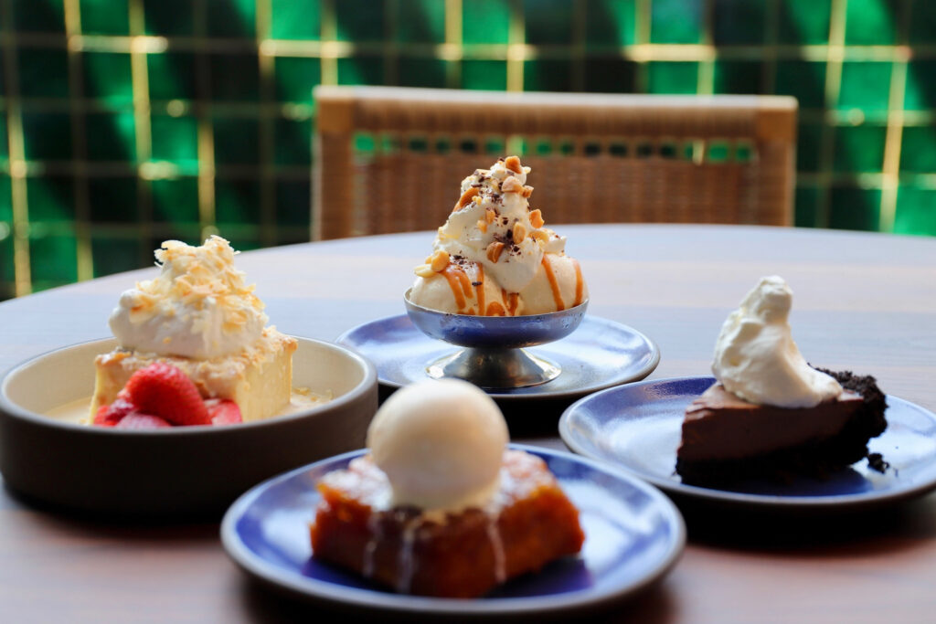 An array of house-made desserts (all $12 each) include coconut quatro leches cake and a miso caramel sundae piled with freshly whipped cream and sprinkled with chocolate shavings and chopped macadamia nuts. (Photo by Courtesy of Western Addition)
