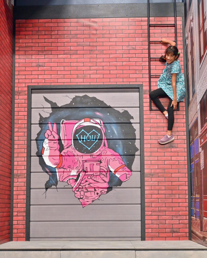 Houston artist, Donkeeboy painted murals for two of the exhibits at the Houston Museum of Illusions, including this building illusion. (Photo by Alex Montoya)