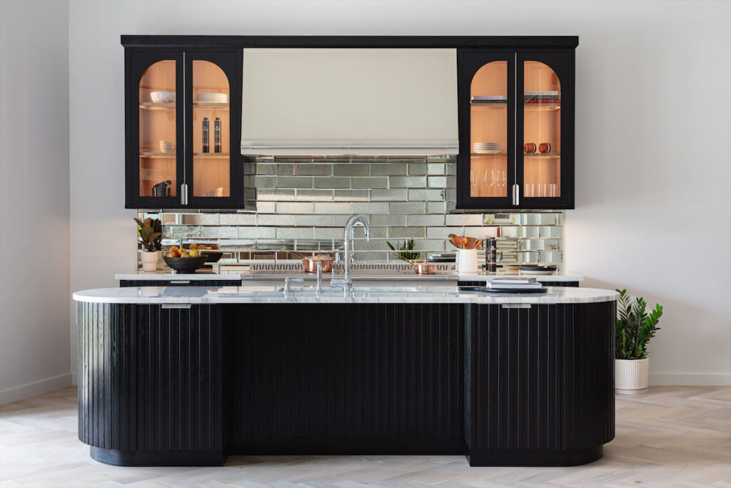 A kitchen island crafted from solid brushed white oak in a noir finish showcases the Le Paris cabinetry. 