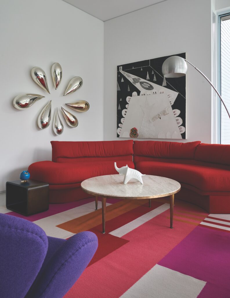 Vintage furniture in sitting area includes a Vladimir Kagan sofa, mid-century coffee table, arc lamp, Arne Jacobsen Swan chair. Custom Vandehurd rug. Trenton Doyle Hancock painting, Jeff Zimmermann sculpture.   (Photo by Pär Bengtsson)
