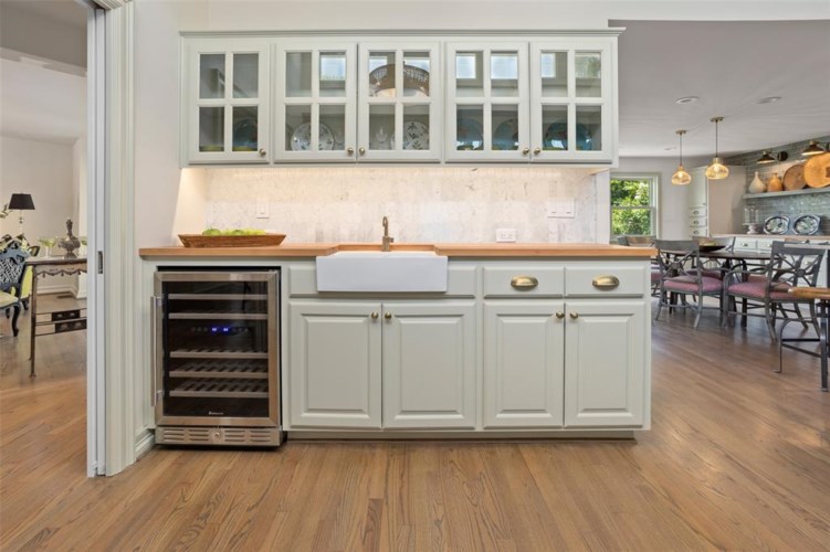 Modern butcher block topped wet bar adds to entertainers layout.