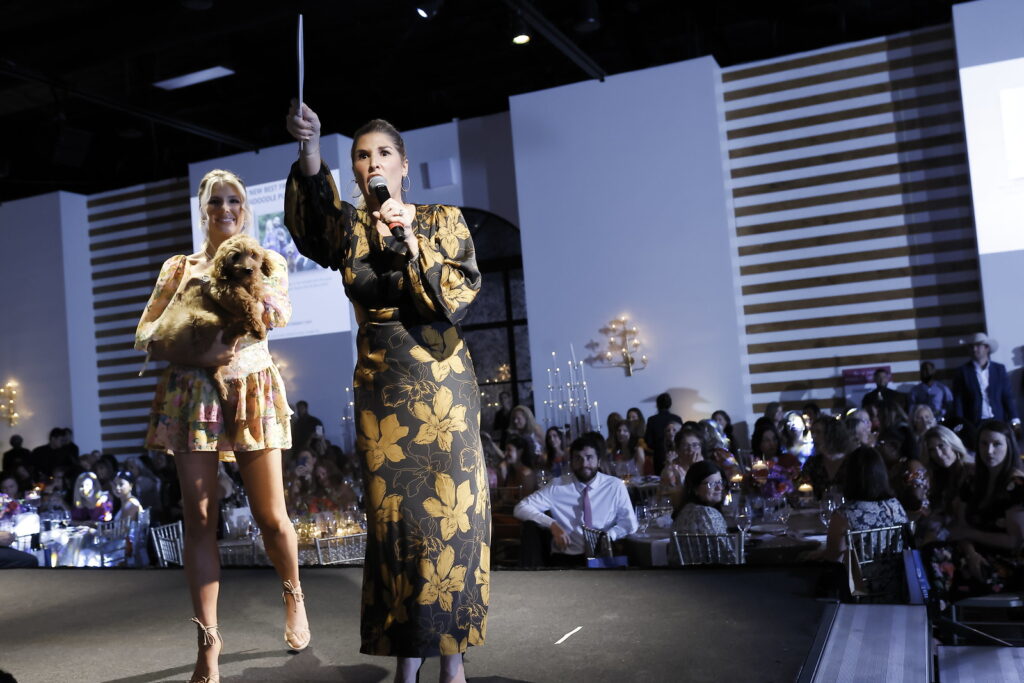 Brittany Hebert Franklin, Sky High for Kids founder and CEO,  conducts the auction at the Ladies Who Brunch benefit for Sky High for Kids at The Revaire. (Photo by Quy Tran Photography)