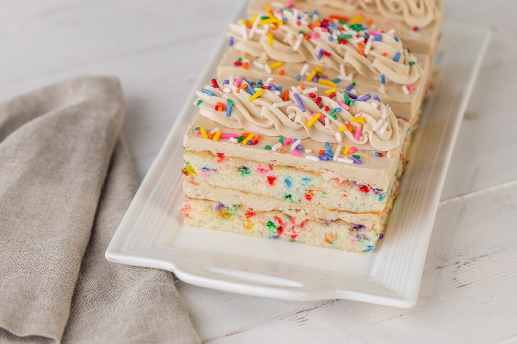 DG Dessert Slabs of giant sheet cakes are perfectly portioned into individual slices and include this funfetti flavor made with vanilla cake, caramel buttercream, and those colorful sprinkles. (Photo by Becca Wright)