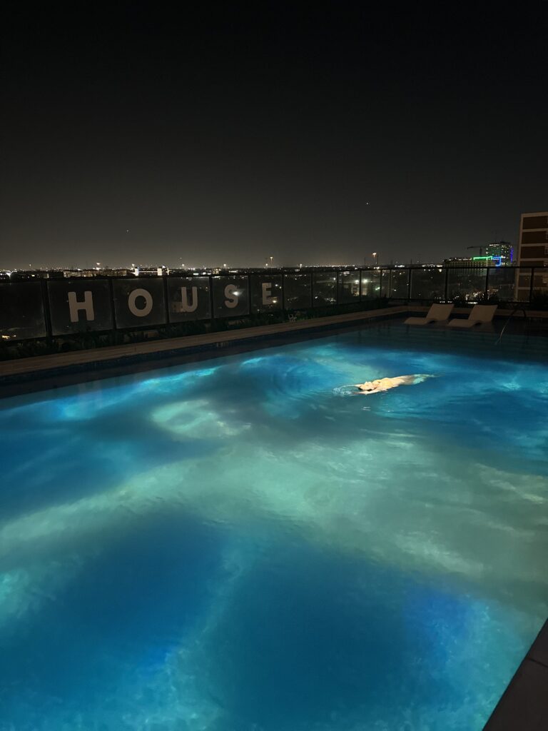 A video of swimmers in the water was projected onto the La Colombe d'Or hotel's pool at the "Surface Tension" reception. (Photo by Haley Berkman Karren) 