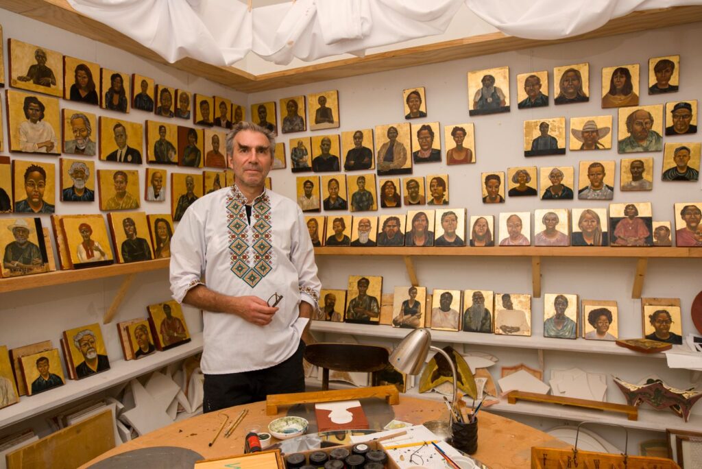 Artist Nestor Topchy appears in his studio next to artworks featured in his solo exhibit "The Iconic Portrait Strand," which remains on view through January 21, 2024 at The Menil Collection. (Photo by Caroline Philippone. Courtesy The Menil Collection)