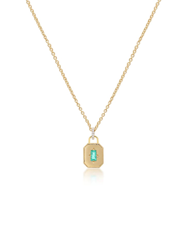 This State Property Spade Warisan Minor Emerald Necklace features an adjustable 18K yellow gold chain and an octagonal charm set with a bright green baguette emerald at its center. 