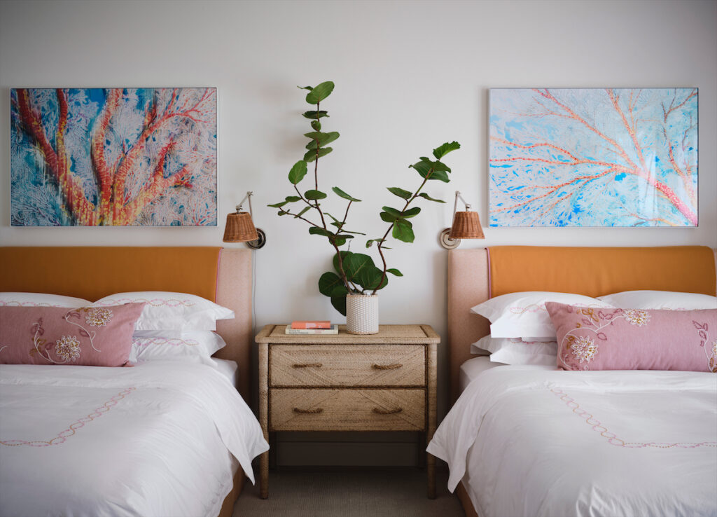 Custom linens in a guest bedroom are by Hamburg
House, and the pillows are embroidered by Joan
Cecil. Underwater photography by Christopher P.
Leidy. Rope nightstand is Curry & Company. Wicker
sconces by Soane Britain. (Photo by Douglas Friedman)