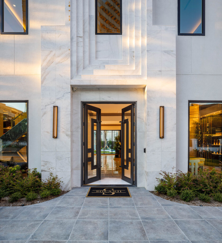 Enter into an impressive solid wrought iron and glass front door opening to the elegant foyer. (Photo by Steve Chenn)