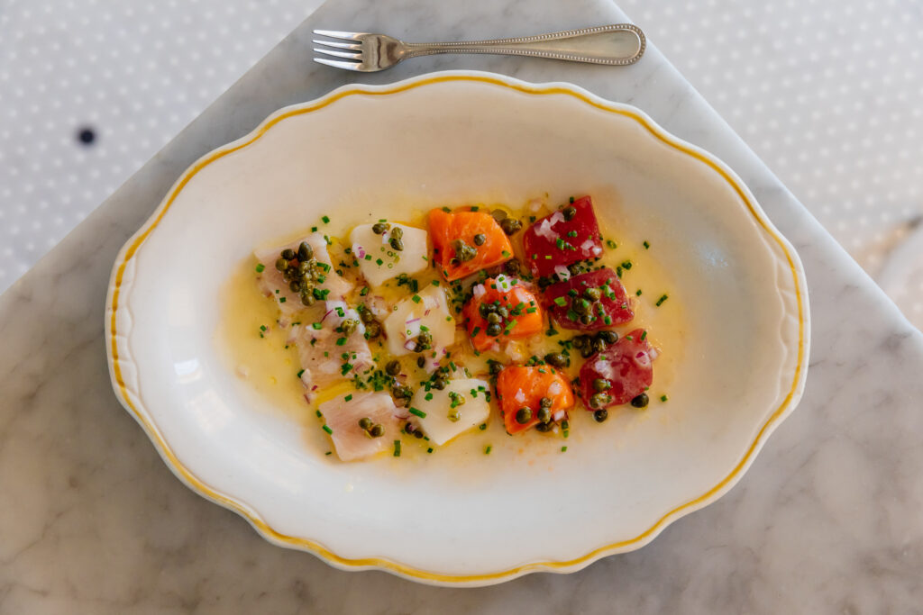 Don’t miss the crudo plate dressed in a wasabi vinaigrette with minced red onions, chives, and capers strewn atop ($25). (Photo by Justin Book)