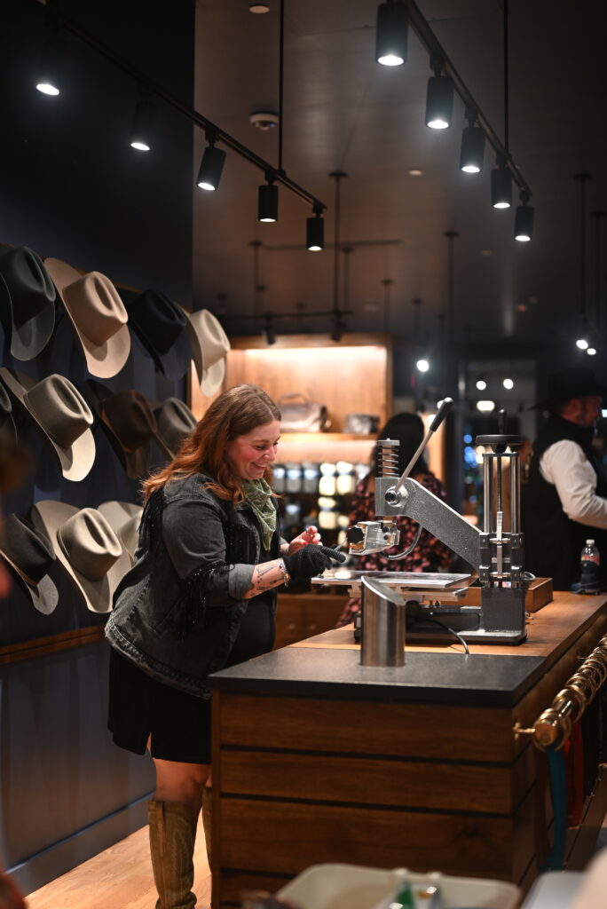 Employees embossed accessories for shoppers during the grand opening of the bootmaker's newest outpost. (Photo by Lucchese Bootmaker)