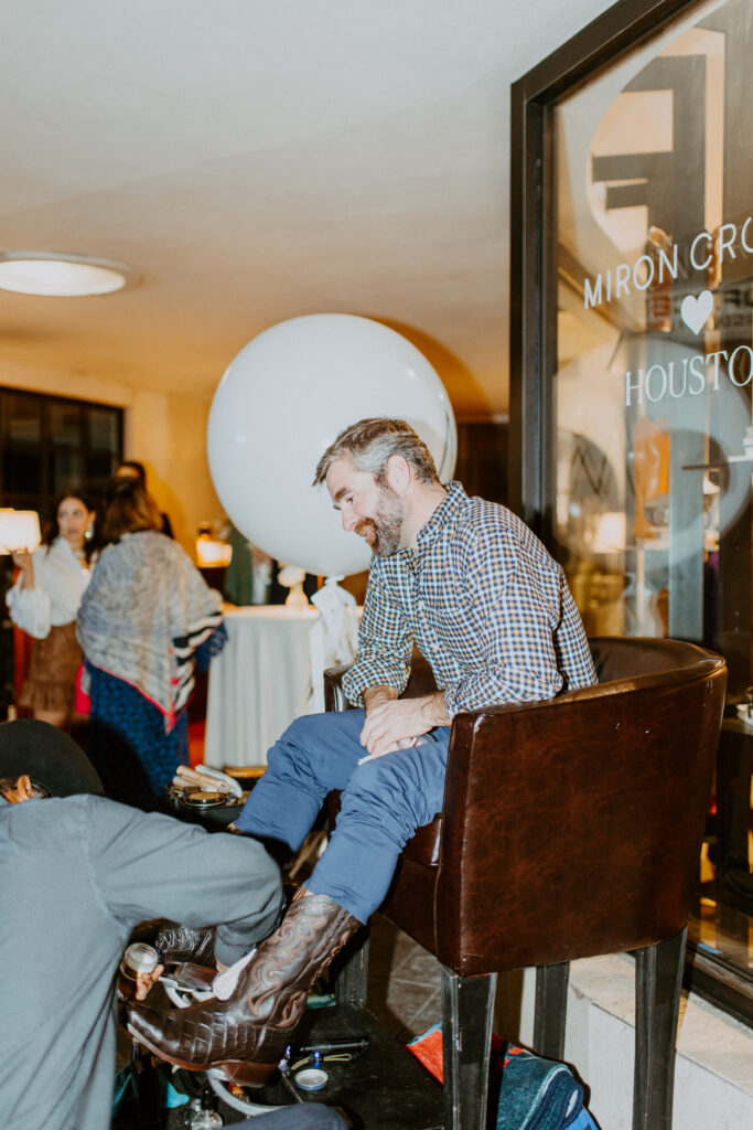 Mack Smith gets a shoe shine fromKen's Shine at the Miron Crosby Houston pre-opening party. (Photo by Emma Umana)