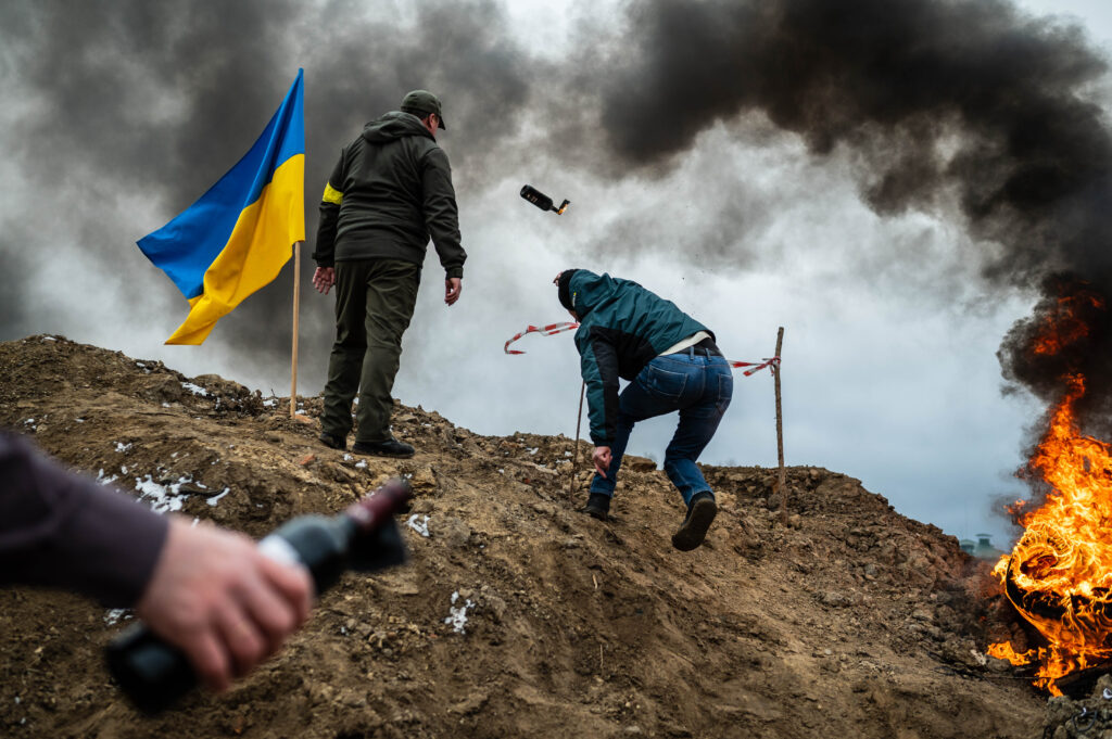 People practice throwing Molotov cocktails in Zhytomyr, Ukraine. March 1, 2022. (Photo by Viacheslav Ratynskyi. Courtesy Ukrainian Association of Professional Photographers.)
