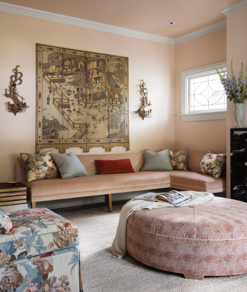 Flanking the fireplace in the living room is a pair of custom banquettes by Kisabeth Furniture, upholstered in Perennials velvet. Custom Kisabeth ottoman. Antique Chinese coromandel screen and sconces from Joseph Minton Antiques. (Photo by Emily Minton Redfield)