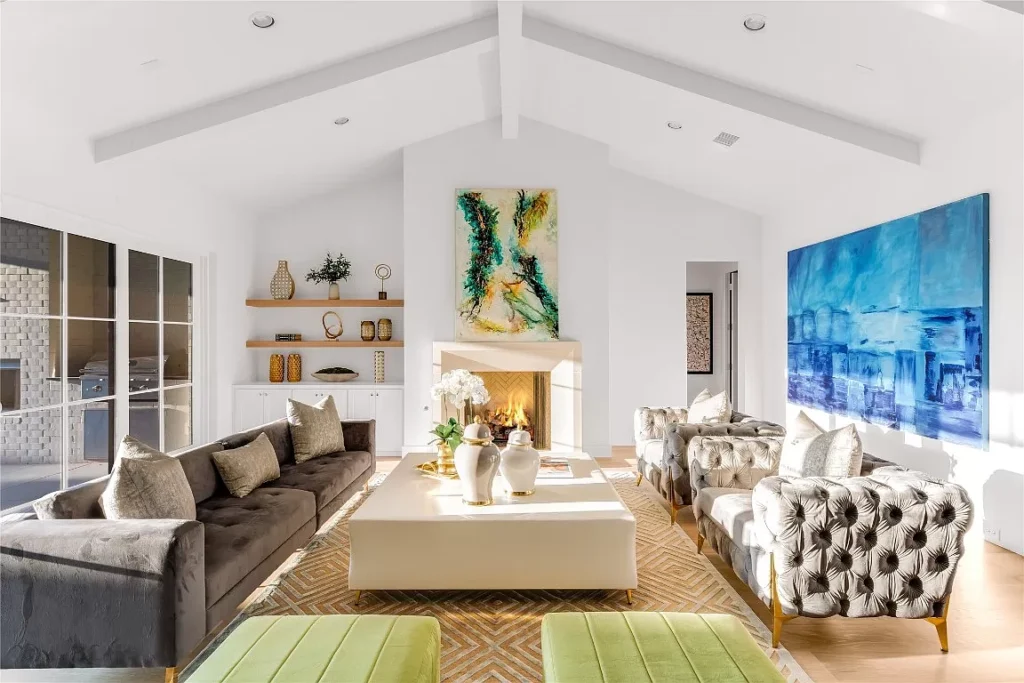 The sun-filled great room offers floating bookshelves and a herringbone-backed fireplace.