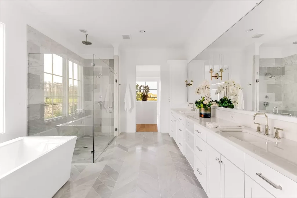 The luxe primary bath features a rain shower, soaking tub, and a massive shared closet.