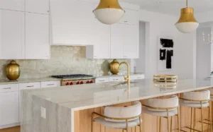 4648 Esprit – The waterfall quartz countertop of the central island with vintage inspired pendant lights