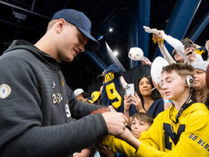 Michigan Wolverines quarterback J.J. McCarthy signs autographs during Media Day at the George R. Brown Convention Center as the City of Houston hosts the NCAA College Football Championship game with the University of Washington facing off against the University of Michigan at NRG Stadium
