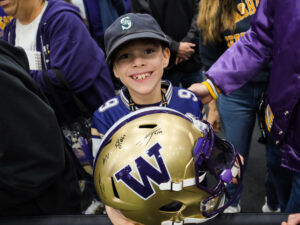 A young Washington Huskies fan hopes to fill his Helmut with signatures during Media Day at the George R. Brown Convention Center as the City of Houston hosts the NCAA College Football Championship game with the University of Washington facing off against the University of Michigan at NRG Stadium