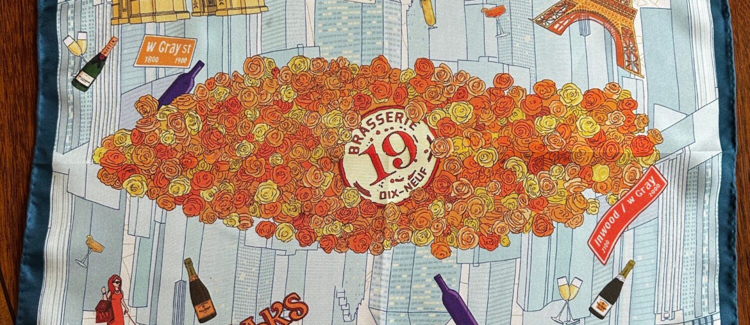 The Brasserie 19 silk scarf features all things French, available only at the River Oaks Shopping Center restaurant.