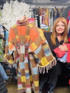 IOTA – Owner Carolyn Young says she has a tough time parting with some special items like this on of a kind embroidered blanket coat. (Photo by Courtney Dabney)