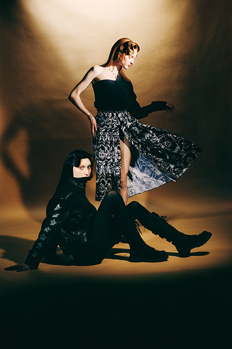 Standing: Dior top $2,250, skirt $7,000, and Toile de Jouy Soleil chocker, at the Dior boutique. Sitting: Dior jacket $7,000 and Diorebel boot $2,650, at the Dior boutique. 