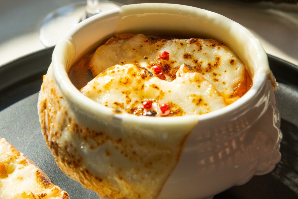 A crock of French onion soup ($14) makes an appearance, too, this one not topped with gruyere but baked provolone cheese and a toasted croute. (Photo by  Shane Dante)