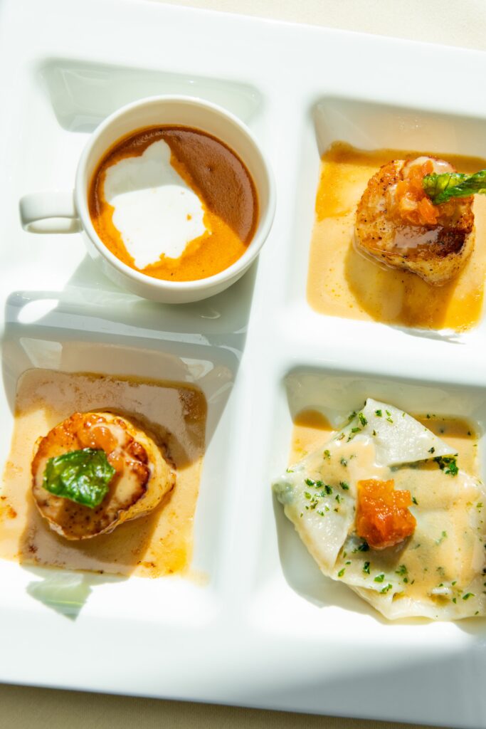 Try a trio of three tastes in this Artisans dish: les noix de Saint Jacques with a pair of pan-seared scallops on a shallow pool of beurre blanc, a blue crab stuffed wonton, and a demitasse of richly flavored lobster cappuccino ($29). (Photo by  Shane Dante)
