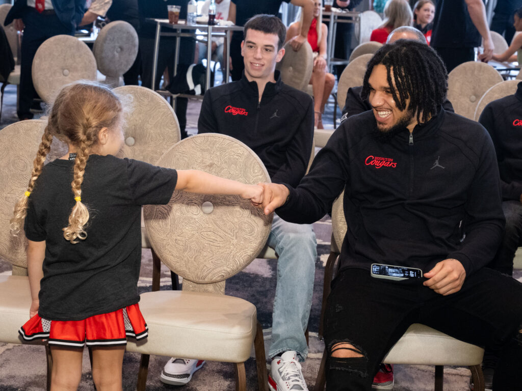 Maisy Jade Sampson and Emanuel Sharp share a first bump at the NCAA Tournament Selection Show watch party. (Photo by F. Carter Smith)