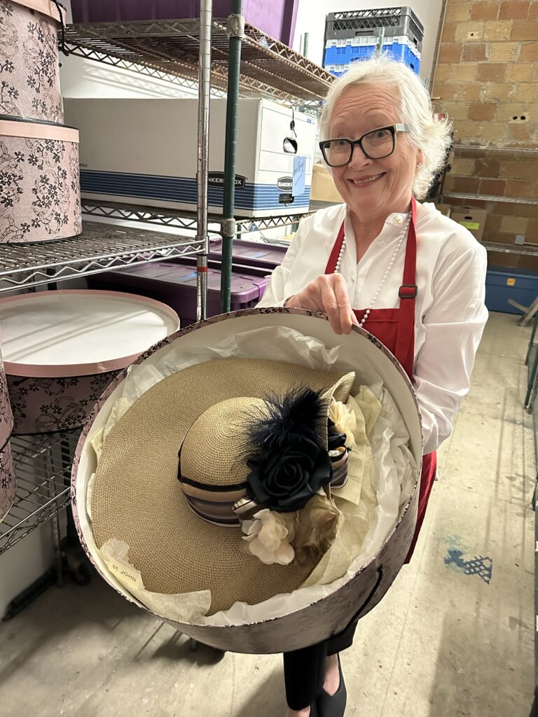 Amanda Gelb, co-chair of the Chic Boutique, displays ome of the fancy hats to be available for sale.  (Photo by Shelby Hodge)