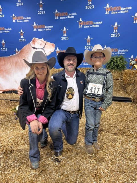 Tony Bradfield with to youngsters who had steers in the 2023 Junior Market Steer Auction at RodeoHouston