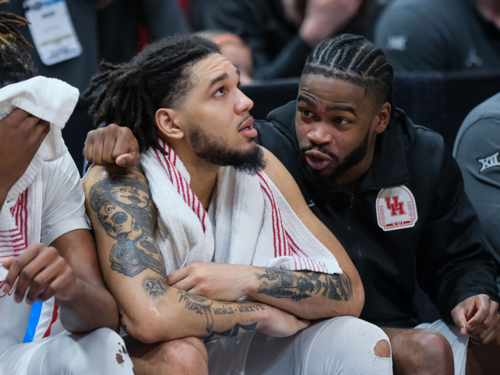 Injured Houston point guard Jamal Shead (right), tried to do what he could to help teammates like Emanuel Sharp while on the bench during that Duke loss. (Photo by F. Carter Smith)