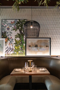 Pops of color come into Costa Fina through artwork. Staghorn ferns line the ceiling, giving off a tropical vibe.