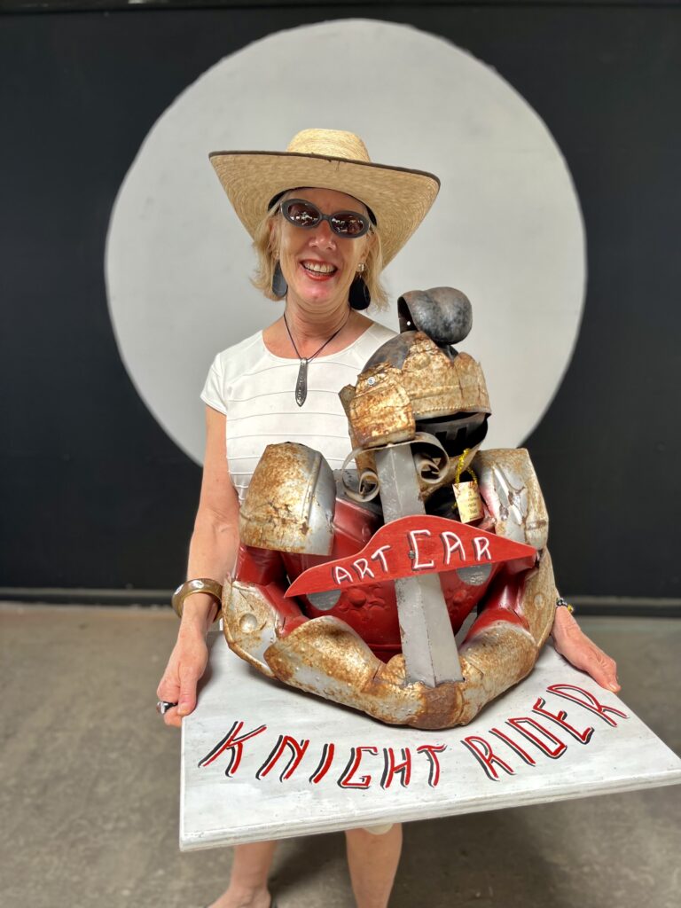 Sarah Gish with award won by LOVE IGNITES! for the painted car category of the 2022 Houston Art Car Parade. (Photo by Jonathan Beitler)