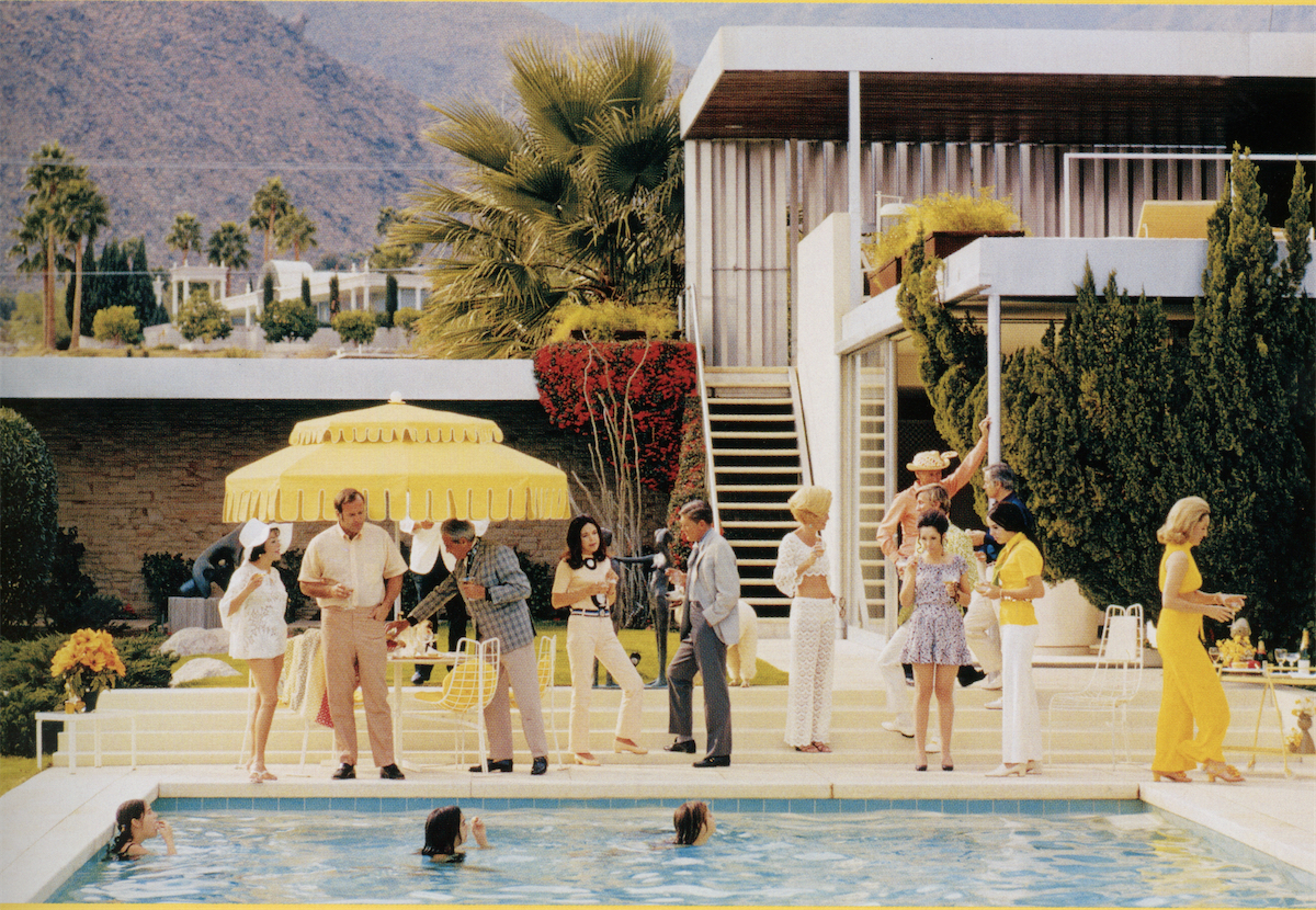262 Slim Aarons’ friend, Nelda Linsk, host and owner of the Kaufmann House by Richard Neutra, Palm Springs, shines in yellow at the far right of the photo