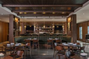 The 5,000 square foot Bar Bludorn, warmed with walnut wood paneling, was designed by Gensler, who was given the mandate to create an intimate space with an airy openness and approachable level of sophistication. (Photo by Claudia Casbarian)