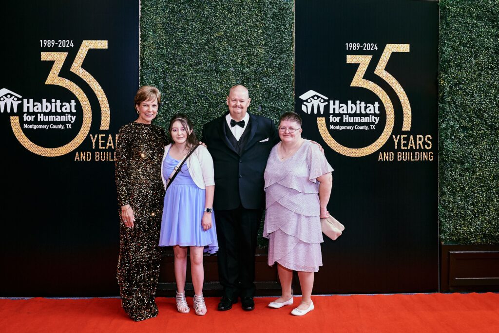 Habitat for Humanity board member Barbara Cargill (left) with recipient family Courtney, Buddy and Deborah have a moment. (Photo by Derrick Bryant)