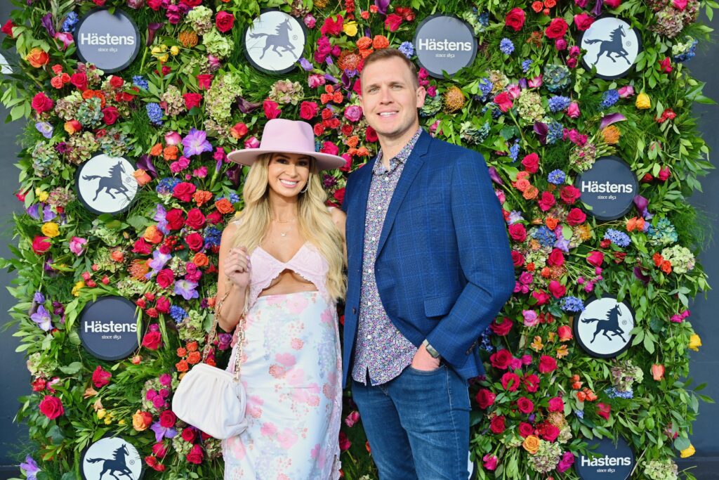 Brooke & Tyler McDonald pose in font of a floral wall before entering Hästens in River Oaks District. (Photo by Alex Montoya)