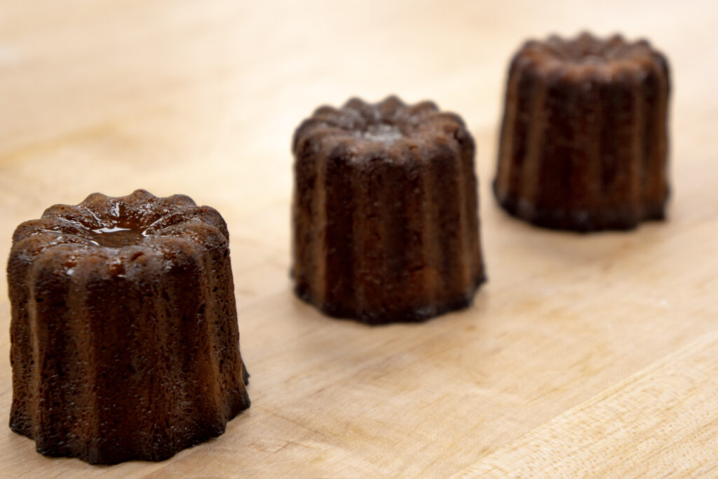 Magnol's cannele de Bordeaux, the dark lilliputian fluted pastries replete with a caramelized crust, conceals a rich custard at its center. (Photo by Reese Littleton)