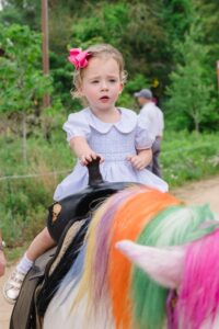 Grace Green enjoying a unicorn ride; Photo by Johnny Than for Jenny Antill